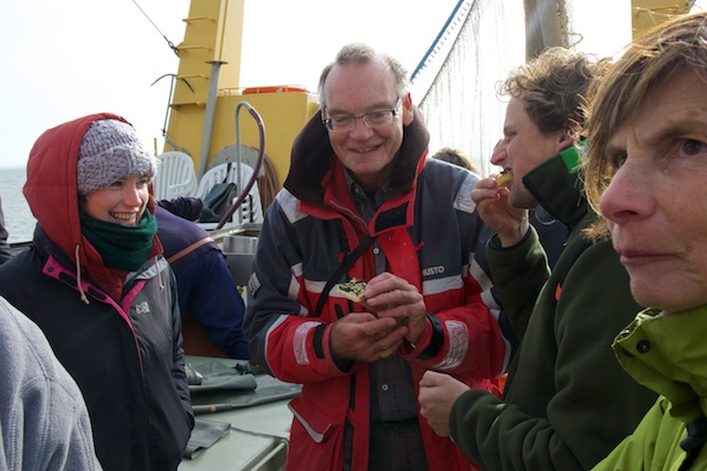 Michel Firet en andere deelnemers eten de zeesla-hajpes