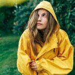 Sad,Young,Blonde,Woman,Looking,Up,,Wearing,Yellow,Raincoat,During